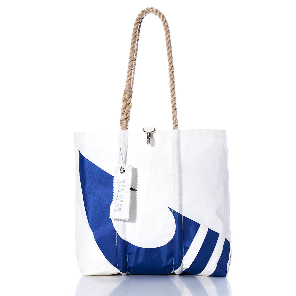 Photographed on a white background, the Sea Bags Vintage C Scow Medium Tote is a white tote bag adorned with a blue abstract design. It features sturdy rope handles and a tag reading SEA BAGS. Handcrafted in Maine, this bag draws inspiration from classic sailboat totes, seamlessly blending maritime tradition with contemporary style. by Sea Bags