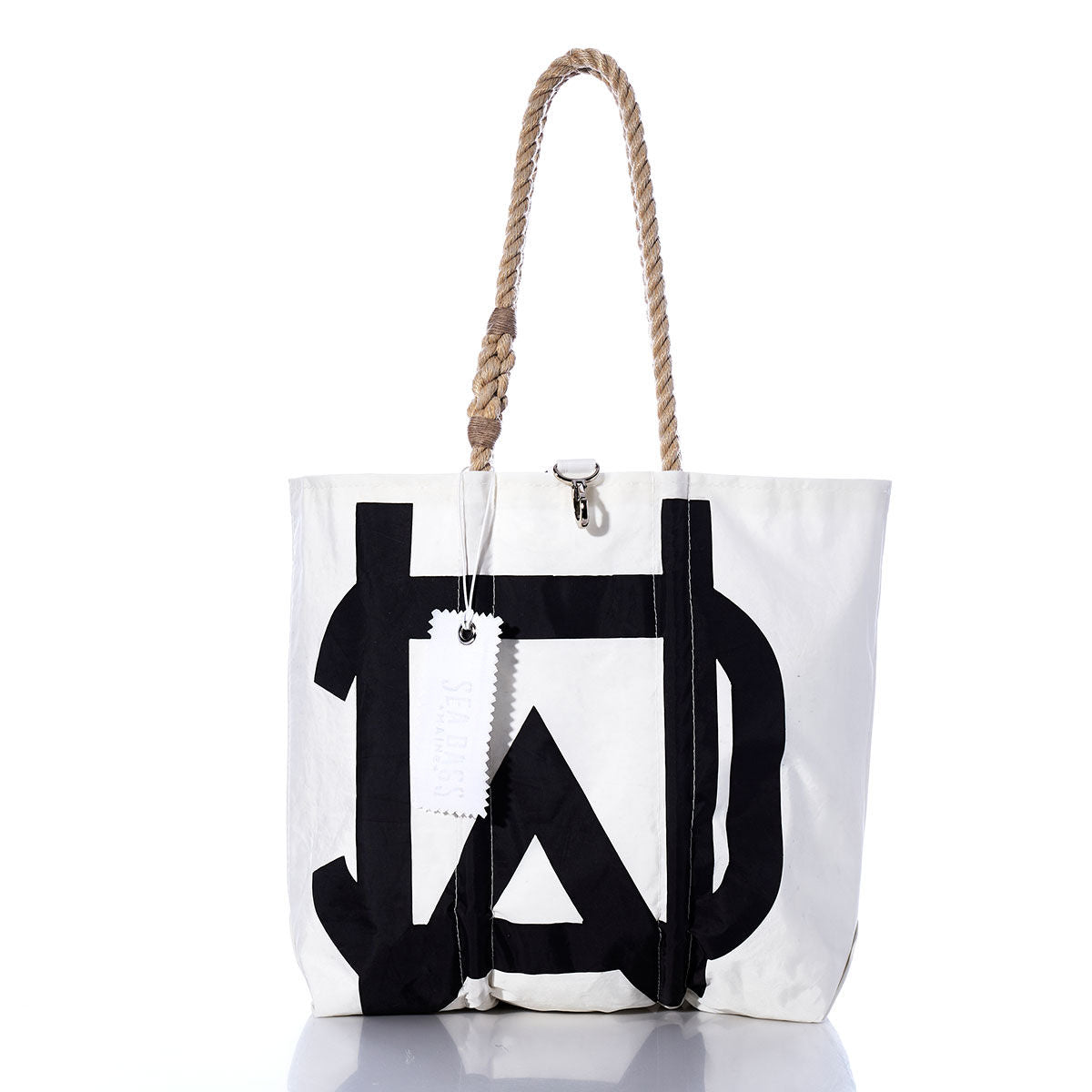 The Sea Bags Vintage Melges Medium Tote, handcrafted in Maine from sailcloth, features a white body with a bold black geometric print, sturdy rope handles, and a white tag. Displayed on a white background, this tote combines durability with timeless style. by Sea Bags