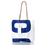 The Sea Bags Vintage Blue 00 Medium Tote features a white and blue sailcloth design with rope handles, a metal zipper, and a white tag attached, all handmade in Maine and displayed against a white background. by Sea Bags