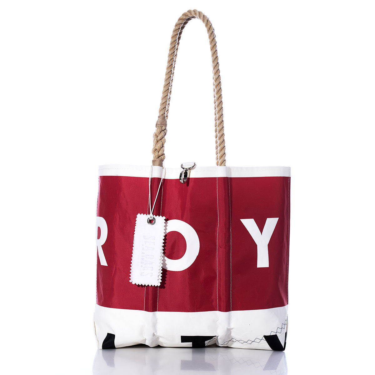 Red and white Sea Bags Vintage ROY Medium Tote with rope handles, featuring large partial white lettering and a white tag attached to one handle, displayed on a white background. Inspired by handcrafted Maine bags, this sailcloth tote is perfect for everyday adventures. by Sea Bags