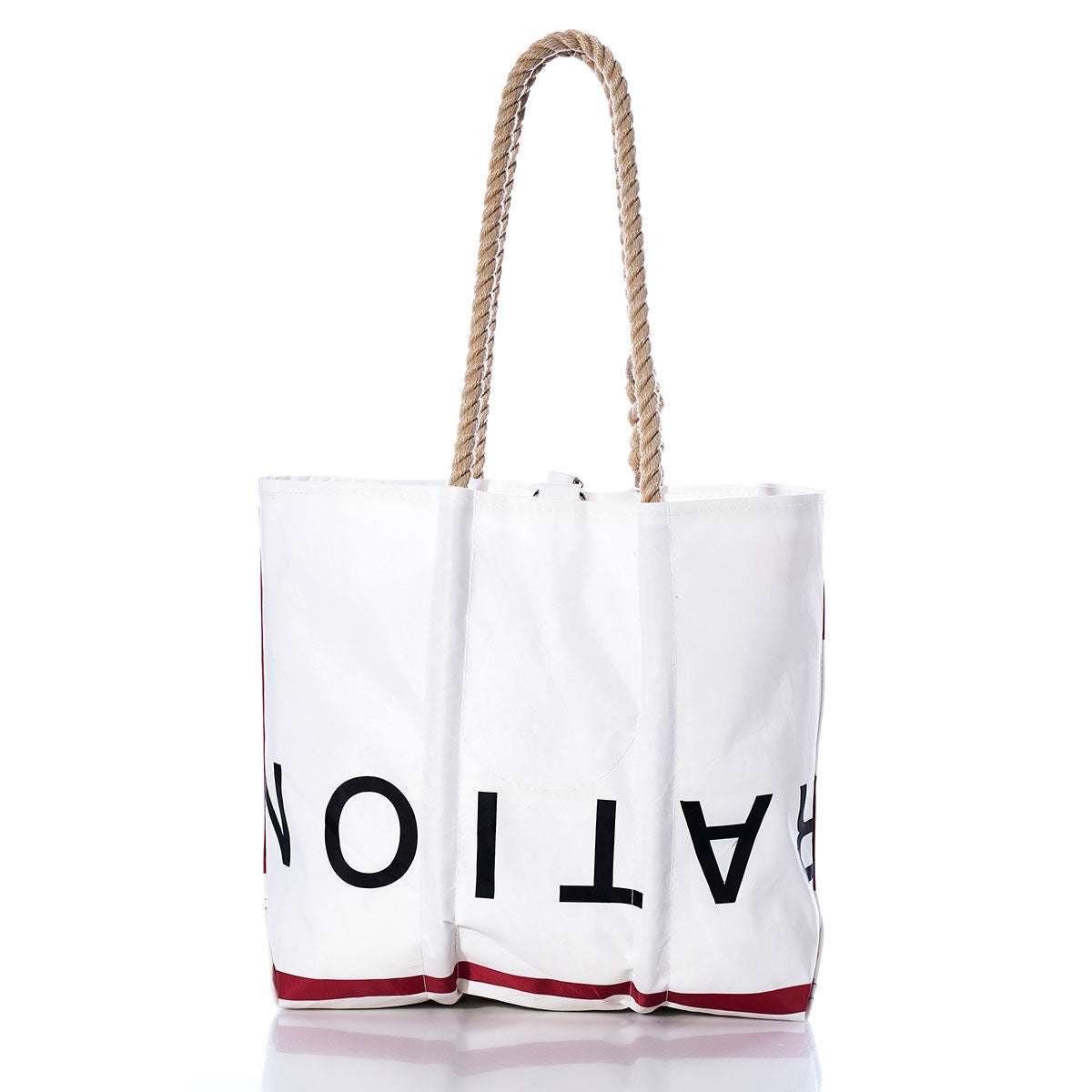 White tote bag with rope handles, showcasing large partial black text and red accents near the bottom, displayed against a plain white background. The Sea Bags Vintage ROY Medium Tote offers timeless style and durability, inspired by traditional handcrafted Maine bags and crafted from authentic recycled sailcloth for lasting quality. by Sea Bags