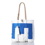 Sea Bags Vintage Blue E Medium Tote: This handmade sailcloth bag from Maine features a white body with a blue geometric design, thick rope handles, visible stitching, and an attached white tag. Photographed on a white background. by Sea Bags