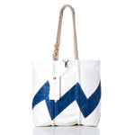 Sea Bags’ Vintage Lightning Medium Tote is a white tote bag accented with a blue zigzag pattern, hand-spliced rope handles, and an authentic sail insignia on the white tag. Displayed on a white background, this bag effortlessly combines nautical charm with timeless style. by Sea Bags