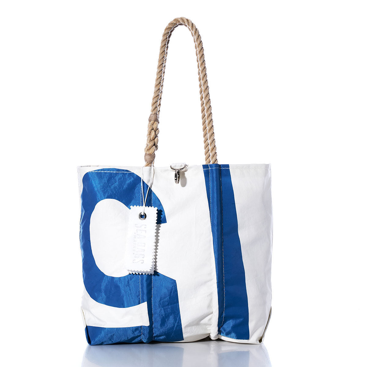 Sea Bags Vintage 15 Medium Tote, featuring white and blue panels, hand-spliced rope handles, and a signature white tag, is photographed on a white background. Inspired by classic sail totes, this piece blends timeless nautical style with practical charm. by Sea Bags