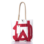 White tote bag with a bold red geometric design, rope handle, and a white tag reading SAIL attached to the handle. The Sea Bags Vintage Melges Medium Tote is crafted from sailcloth and takes inspiration from handmade Maine bags, showcasing the brands signature classic style. by Sea Bags