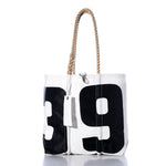 Sea Bags’ Vintage 39 Medium Tote—a white tote featuring bold black numbers 3 and 9, thick hand-spliced rope handles, and a white tag—is inspired by Maine handcrafted bags and displayed against a clean white background. by Sea Bags