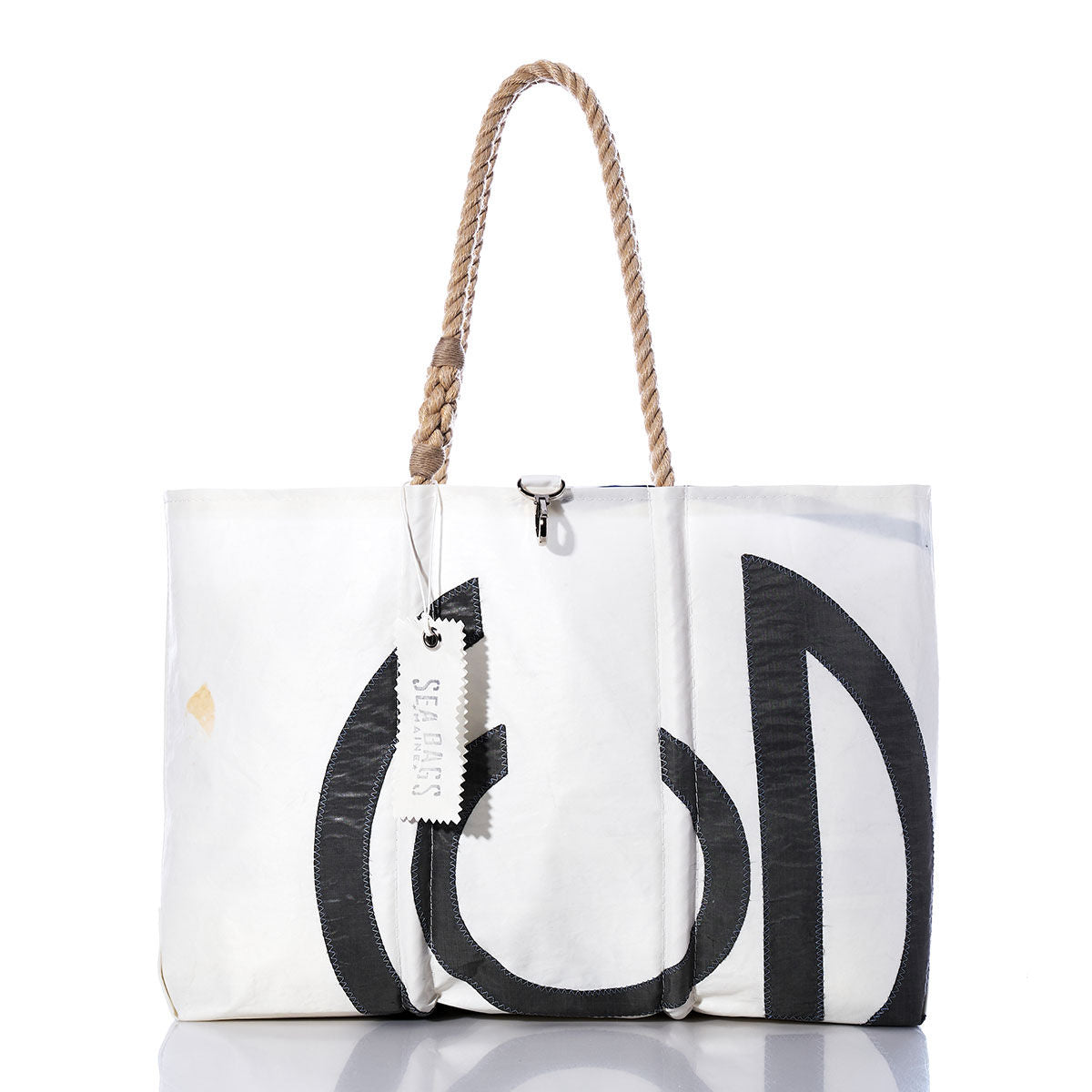 Vintage CG Large Tote by Sea Bags: This handmade sailcloth tote from Maine features black graphic accents, a rope handle, and a white tag bearing the Sea Bags name. The bag is photographed against a white background with a subtle reflection beneath it. by Sea Bags