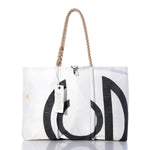 Vintage CG Large Tote by Sea Bags: This handmade sailcloth tote from Maine features black graphic accents, a rope handle, and a white tag bearing the Sea Bags name. The bag is photographed against a white background with a subtle reflection beneath it. by Sea Bags