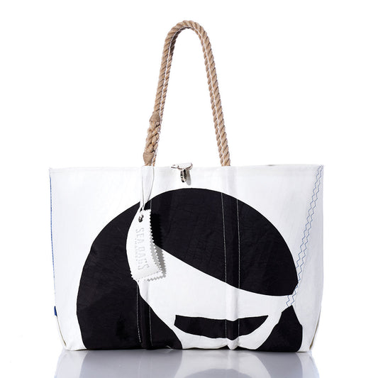 White tote bag featuring a black graphic design, rope handles, and a rectangular tag. The Sea Bags Vintage Sea Sprite Large Tote is expertly handcrafted in Maine from durable sailcloth, blending style with function. Displayed against a plain white background with a subtle reflection underneath. by Sea Bags
