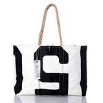 The Vintage 150 Large Tote by Sea Bags is a large white and black rectangular bag with hand-spliced rope handles and an attached SEABAGS tag. Handcrafted in Maine, it is displayed on a reflective surface against a white background. by Sea Bags