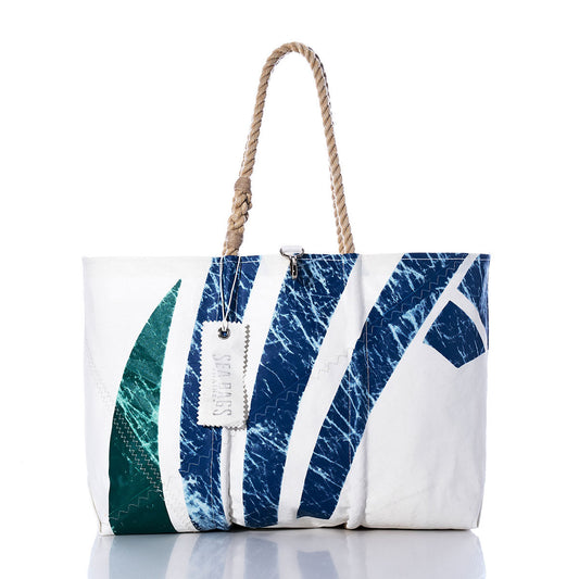 The Sea Bags Vintage Seahawk Large Tote is crafted from white sailcloth and showcases blue and green wave patterns, sturdy rope handles, and a white tag accent. Displayed against a plain white background, this tote draws inspiration from handmade Maine bags, blending nautical charm with practical style. by Sea Bags