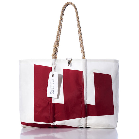The Vintage Etchells Large Tote by Sea Bags features a bold red geometric pattern on white sailcloth, sturdy rope handles, and the signature Sea Bags brand tag. Photographed against a white background, this handmade Maine tote showcases distinctive style and superior craftsmanship. by Sea Bags