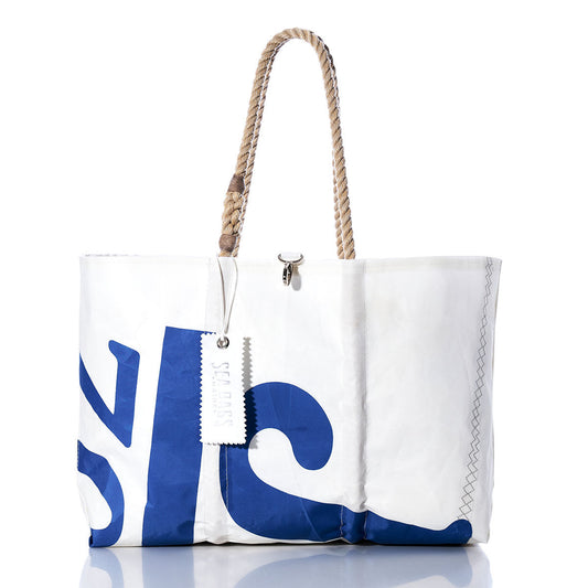 Crafted by Sea Bags from repurposed sailcloth, the Vintage J70 Large Tote features blue lettering, rope handles, visible stitching, and a hanging tag. This white tote bag is handmade in Maine and photographed against a white background. by Sea Bags