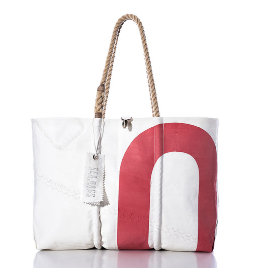 The Sea Bags Vintage Red 0 Large Tote features hand-spliced rope handles, a bold red curved design, and a Sea Bags tag, all crafted in Maine from authentic recycled sail material. Photographed against a white background, this tote embodies true Maine craftsmanship. by Sea Bags