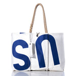 The Sea Bags Vintage US Large Tote is shown on a white background, featuring large blue S and N lettering, hand-spliced rope handles, and a white tag attached. This signature Maine-crafted bag exemplifies the brand’s classic style. by Sea Bags