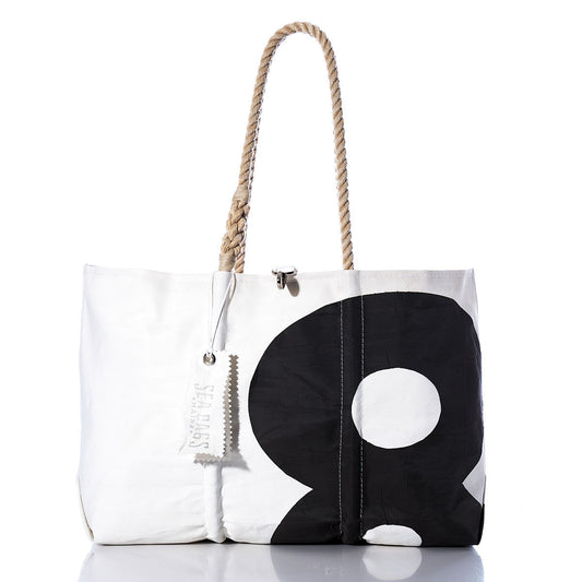Introducing the Sea Bags Vintage Black 8 Large Tote, crafted from recycled sails with original sail insignia and hand-spliced rope handles. This spacious white and black tote features a striking number 8 graphic and includes a distinctive white tag. Photographed on a plain white background. by Sea Bags