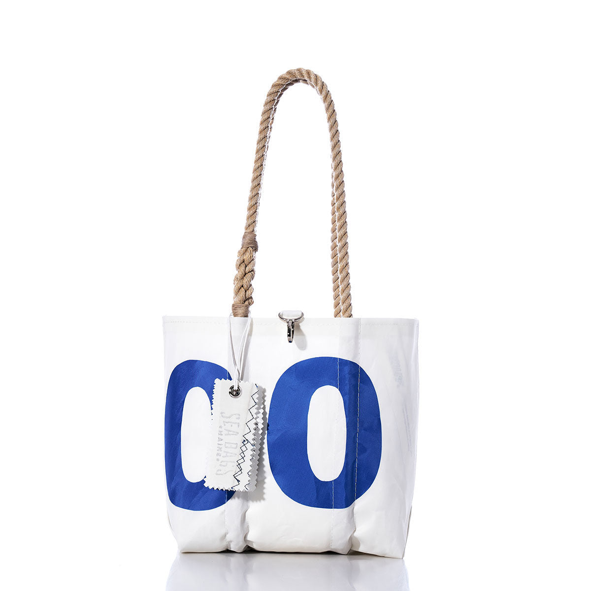 Sea Bags’ Vintage 0 Handbag features a plain white design accented with subtle sail insignias, blue lettering, and sturdy hemp rope handles. A tag is attached, and the nautical details lend timeless charm to this classic tote. by Sea Bags