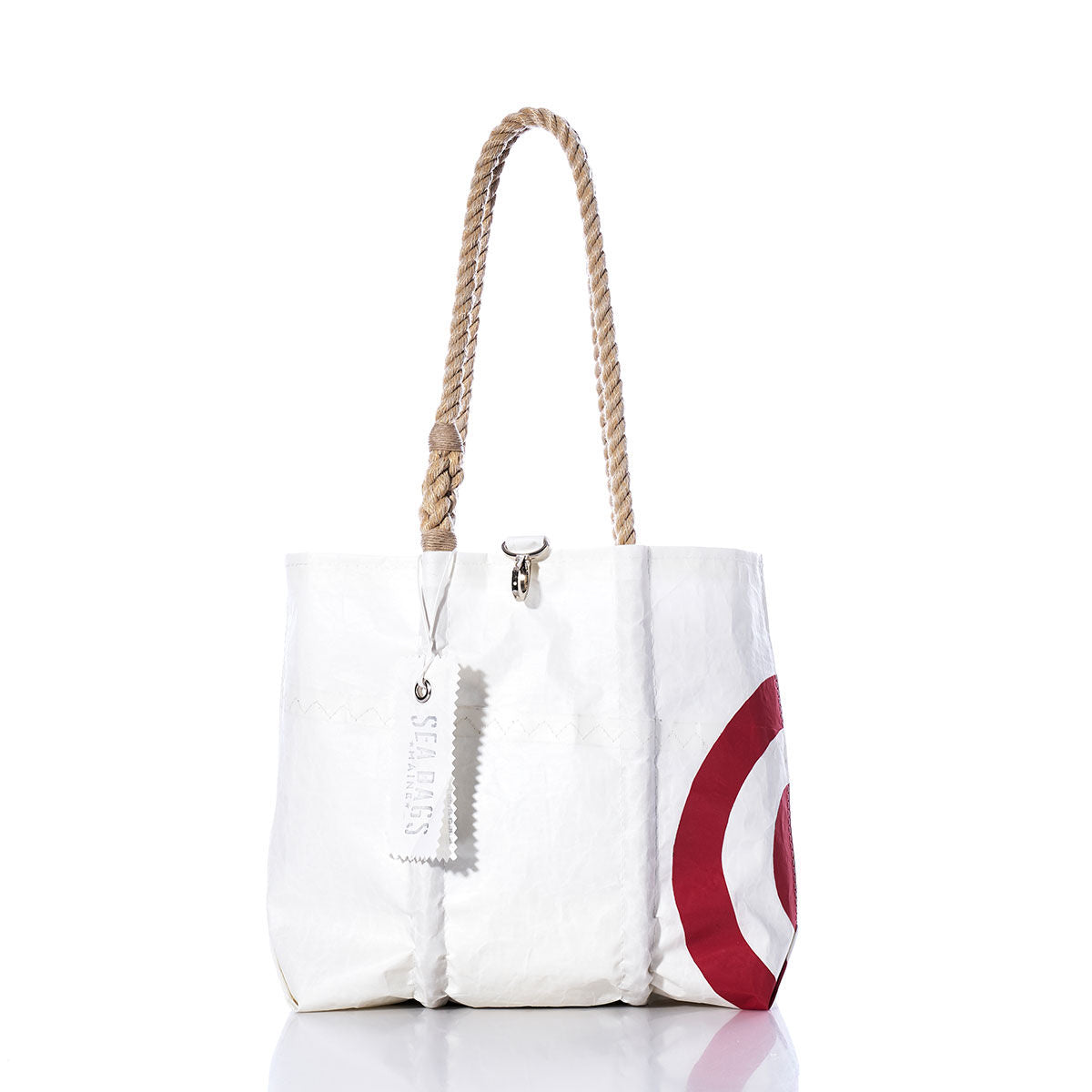 Sea Bags Vintage Bullseye Handbag: White tote bag featuring sturdy hemp rope handles, a stitched SEABAGS tag, and a distinctive red partial bullseye sail insignia on one side—all showcased against a white background to evoke the timeless Vintage Bullseye Handbag style. by Sea Bags