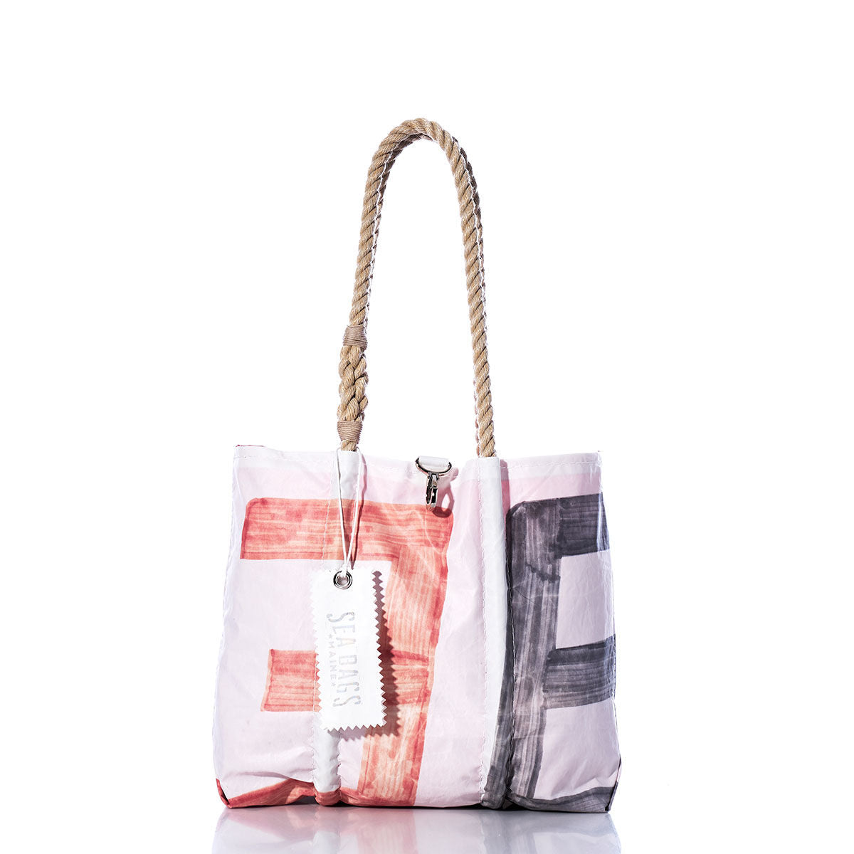 A Sea Bags Vintage 36 Handbag tote with hemp rope handles, showcasing a red and black abstract sail insignia pattern and a white tag, displayed on a white background. by Sea Bags