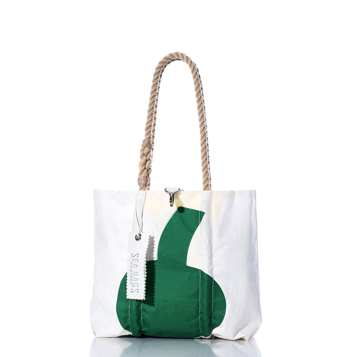 Sea Bags’ Vintage Thistle Handbag features a white tote design with a green abstract shape, hemp rope handles, and an attached “Sea Bags” tag. The bag stands upright on a reflective surface against a plain white background. by Sea Bags