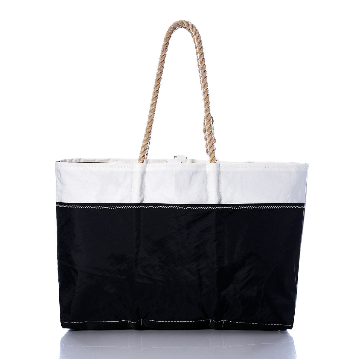 The Sea Bags Vintage Allmand Ogunquit Beach Tote is a spacious tote bag made from recycled sail cloth, showcasing a white upper section, black lower section, and two strong rope handles, photographed against a white background. by Sea Bags