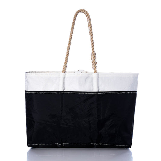 The Sea Bags Vintage Allmand Ogunquit Beach Tote is a spacious tote bag made from recycled sail cloth, showcasing a white upper section, black lower section, and two strong rope handles, photographed against a white background. by Sea Bags
