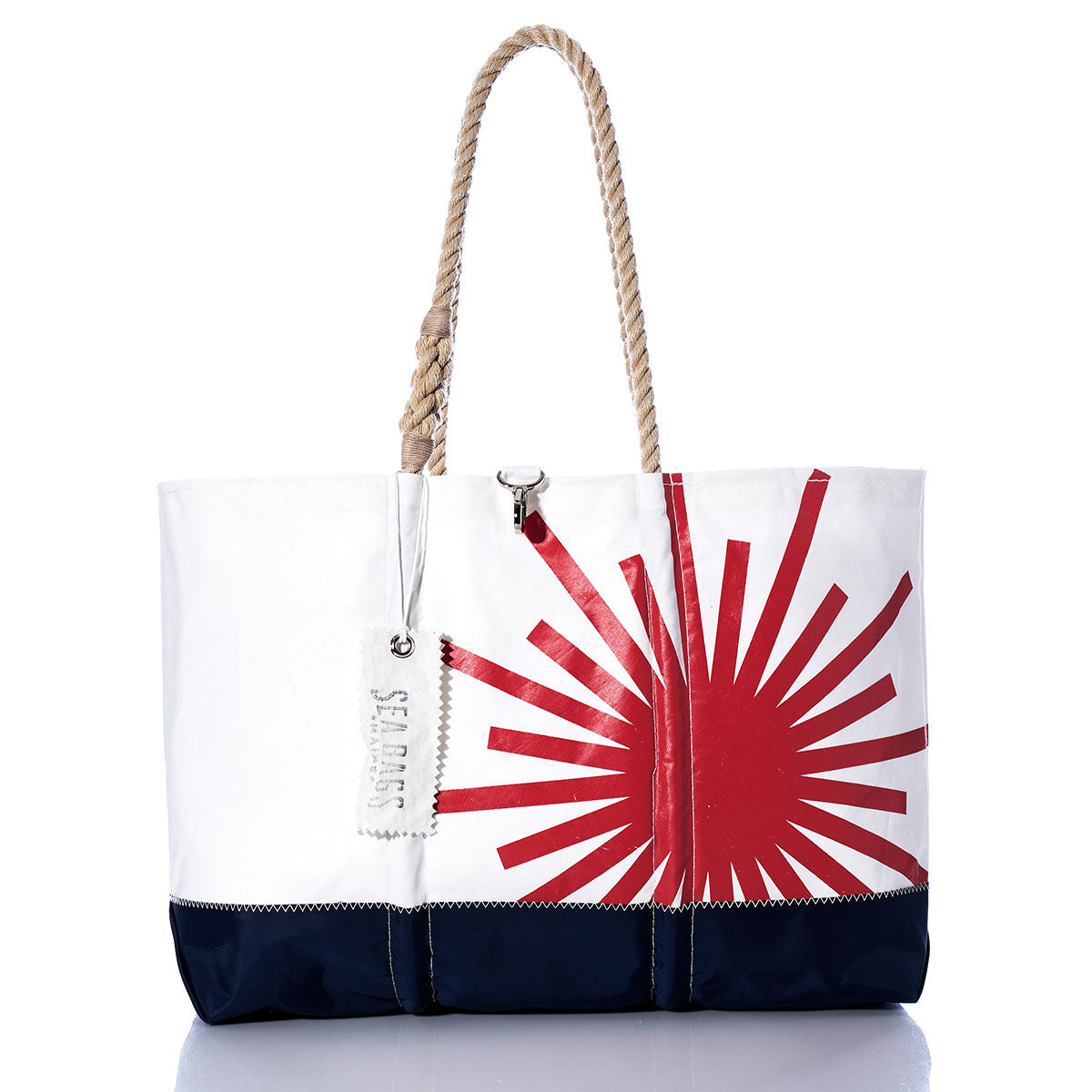 Introducing the Vintage Laser Ogunquit Beach Tote by Sea Bags—a spacious beach tote crafted from recycled sail cloth, featuring a striking red sunburst graphic on white with a navy blue bottom. Designed with sturdy rope handles and finished with a distinctive white “SEA BAGS” tag attached to the handle, this eco-friendly accessory brings effortless seaside style to your summer adventures. by Sea Bags