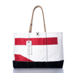 Introducing the Vintage Red 71 Ogunquit Beach Tote by Sea Bags—a spacious white tote bag made from recycled sail cloth, adorned with bold red and black rectangular accents. It features sturdy rope handles and a signature Sea Bags tag attached to one handle, seamlessly combining timeless style and eco-friendly craftsmanship inspired by classic sail designs. by Sea Bags