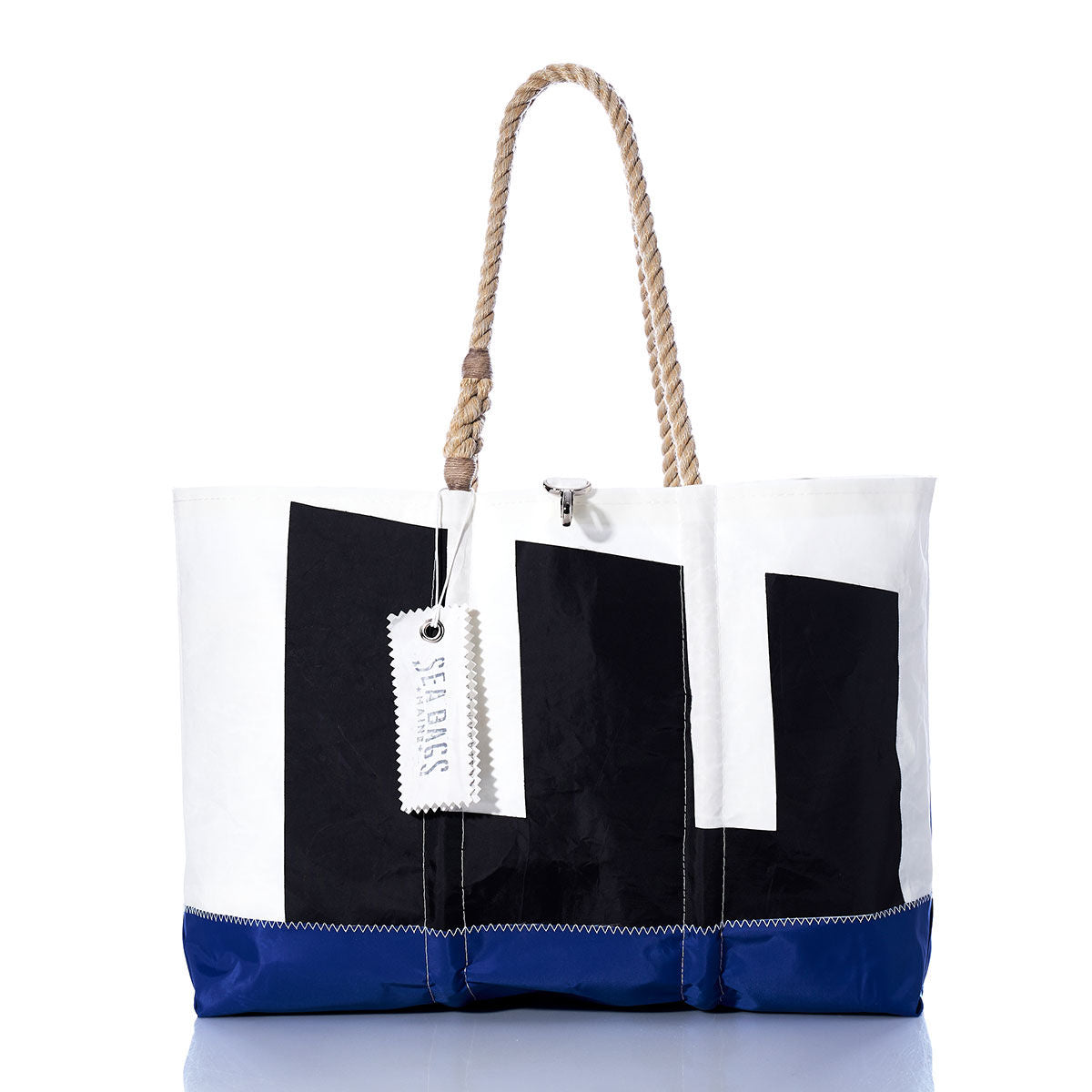 Introducing the Vintage Etchells Ogunquit Beach Tote by Sea Bags—a spacious beach tote crafted from recycled sail cloth, distinguished by its blue bottom, white upper section, bold black geometric shapes, sturdy rope handles, and signature SEA BAGS tag. This tote effortlessly blends vintage Etchells charm with modern coastal style. by Sea Bags