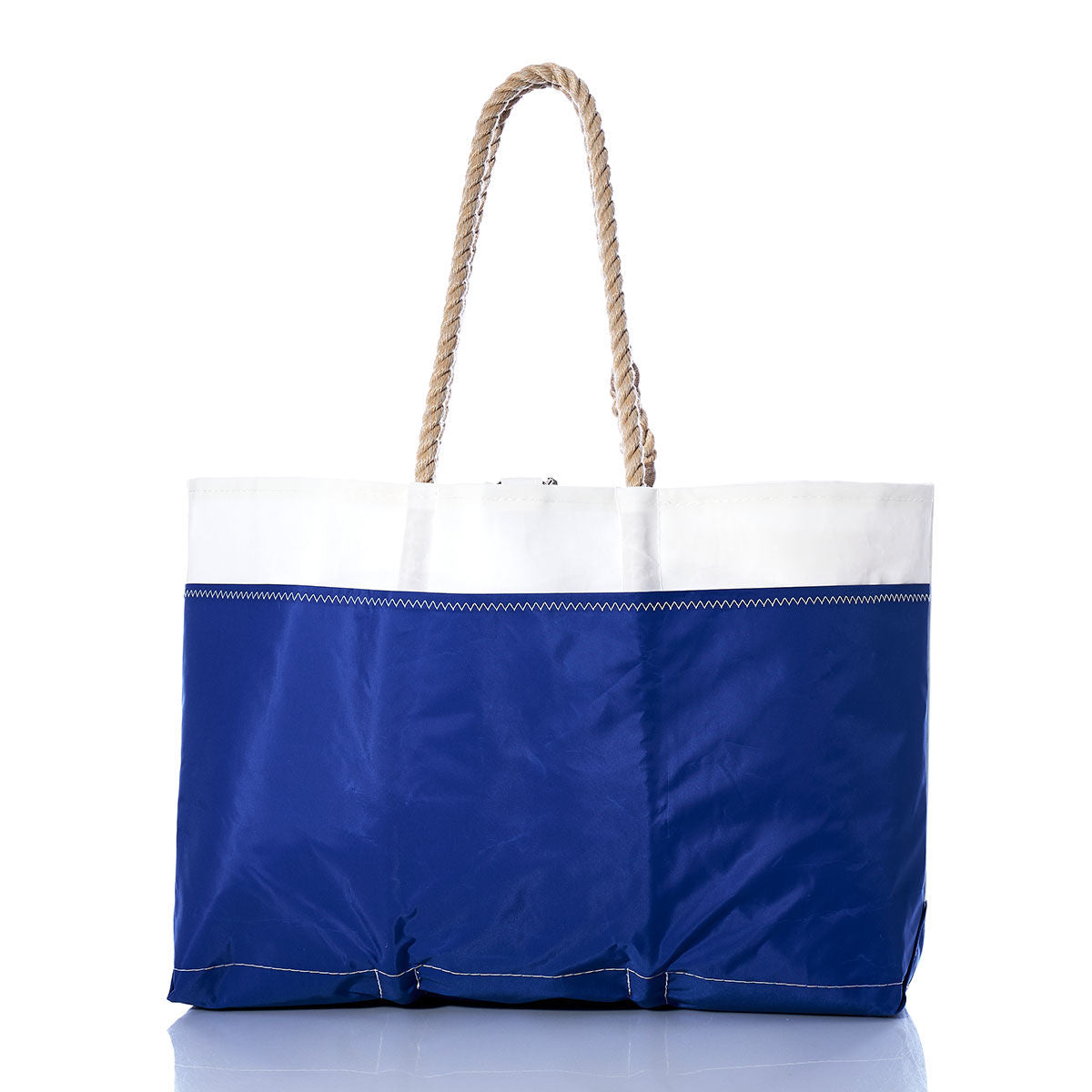 The Sea Bags Vintage Etchells Ogunquit Beach Tote, crafted from recycled sail cloth in blue and white and featuring sturdy rope handles, is displayed on a reflective surface against a white background. by Sea Bags