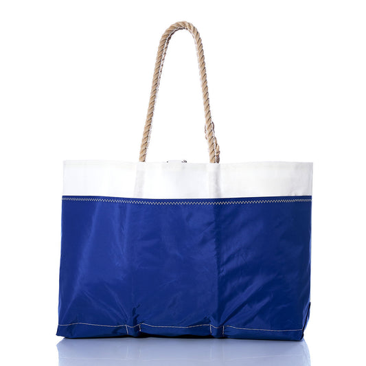 The Sea Bags Vintage Etchells Ogunquit Beach Tote, crafted from recycled sail cloth in blue and white and featuring sturdy rope handles, is displayed on a reflective surface against a white background. by Sea Bags