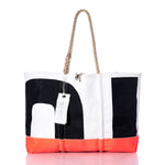 The Sea Bags Vintage Black 01 Ogunquit Beach Tote features striking black and white color blocks, an orange bottom trim, and sturdy rope handles, all crafted from recycled sail cloth. Finished with a white tag labeled “FEARLESS,” this large tote bag combines vintage sail charm with bold, practical style. by Sea Bags