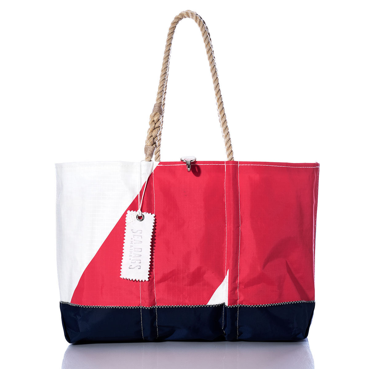 Introducing the Vintage Red 4 Ogunquit Beach Tote by Sea Bags—a spacious beach tote crafted from recycled sail cloth and designed with bold white, red, and navy color blocks. Finished with sturdy rope handles and a signature white Sea Bags tag, this accessory channels timeless style inspired by vintage sails. by Sea Bags