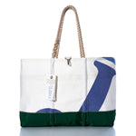 The Sea Bags Vintage J105 Ogunquit Beach Tote is a spacious beach tote bag with rope handles, crafted from white, green, and blue recycled sail cloth. It features a nautical design and comes with a hanging tag. by Sea Bags