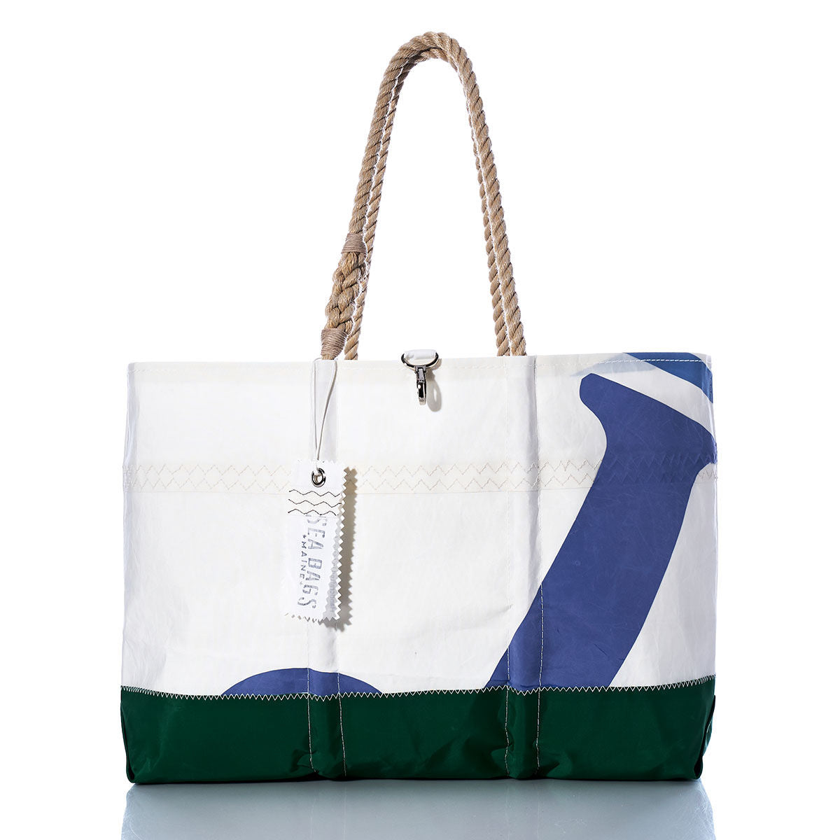 The Sea Bags Vintage J105 Ogunquit Beach Tote is a spacious beach tote bag with rope handles, crafted from white, green, and blue recycled sail cloth. It features a nautical design and comes with a hanging tag. by Sea Bags