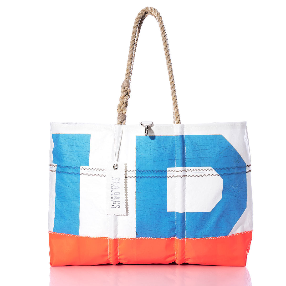 The Vintage Blue IP Ogunquit Beach Tote by Sea Bags features bold blue, white, and orange color blocks crafted from recycled sail cloth. With sturdy rope handles and a silver tag, this large beach tote beautifully blends style, sustainability, and seaside charm—shown perfectly against a white background. by Sea Bags