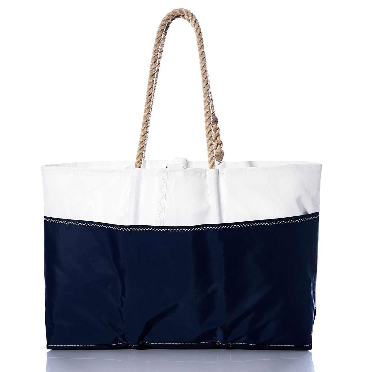 The Vintage Ensign Ogunquit Beach Tote by Sea Bags is a spacious bag made from recycled sail cloth, featuring a white top, navy blue bottom, and sturdy twisted rope handles, elegantly showcased against a white background. by Sea Bags