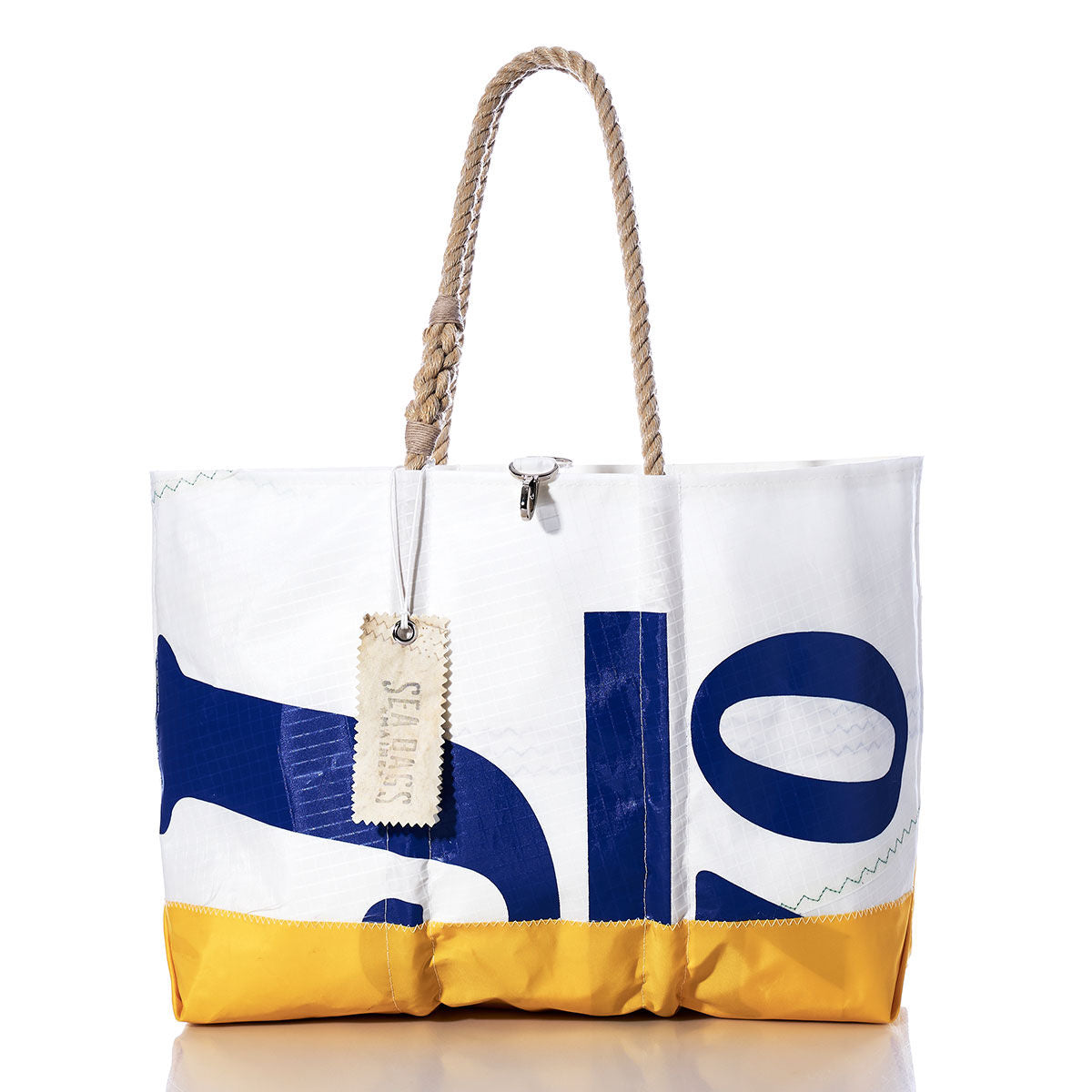 The Vintage J70 Ogunquit Beach Tote by Sea Bags is crafted from recycled sail cloth, featuring a yellow bottom, blue printed letters, sturdy rope handles, and a stitched SEABAGS tag attached to one handle. by Sea Bags