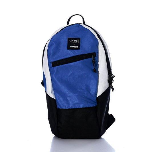 The Sea Bags Vintage Blue and White Crew Backpack is a sustainable accessory, crafted from recycled sail cloth in hues of blue, black, and white. It features a front zip pocket and the signature Sea Bags label, showcased against a white background. by Sea Bags