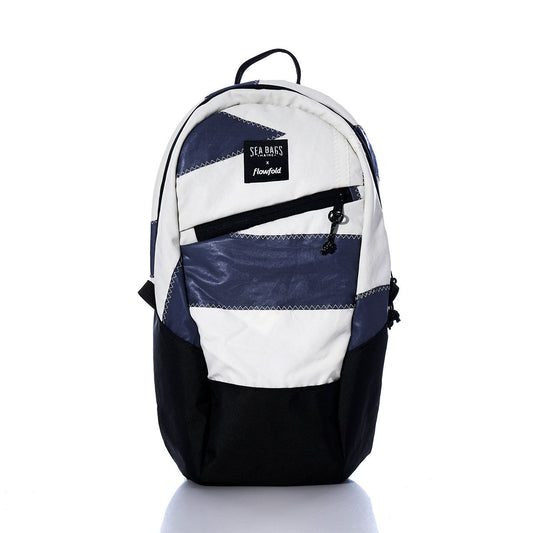 The Sea Bags Vintage Dark Purple Crew Backpack—a sustainable backpack made from recycled sail cloth—features white, navy, and black striped panels, two zippered pockets, and a front SEABAGS label. Photographed on a white background, this eco-friendly pack blends classic style with durability for everyday adventures. by Sea Bags