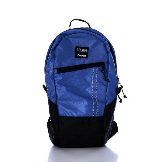 Introducing the Sea Bags Vintage Blue Crew Backpack, expertly crafted from recycled sail cloth. This sustainable backpack features a striking blue and black design, complete with a front zipper pocket, two side pockets, and a convenient top handle. Displayed against a white background, the Sea Bags Vintage Blue Crew Backpack blends eco-friendly materials with timeless style—perfect for everyday use. by Sea Bags