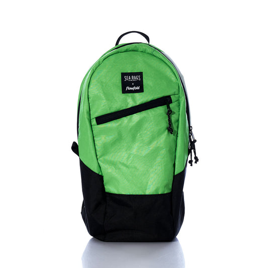 The Sea Bags Vintage Green Crew Backpack, crafted from recycled sail cloth and featuring a front zipper pocket along with a SEA BASS Handfield label, stands upright on a white background—making it an ideal sustainable backpack choice for eco-conscious adventurers. by Sea Bags