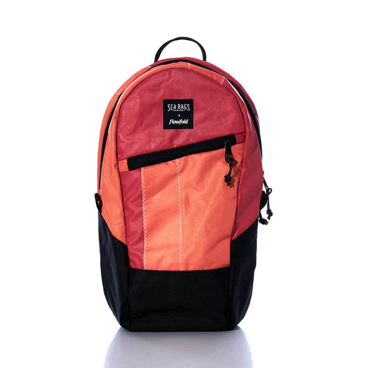 Vintage Red and Orange Crew Backpack by Sea Bags, featuring a black bottom, front zipper pocket, and a SEA BAGS x Flowfold label on the front. Crafted from recycled sail cloth and displayed against a white background. by Sea Bags