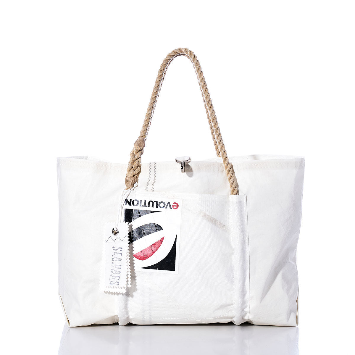 Sea Bags’ Vintage Evolution Wharf Tote, crafted in Portland, Maine from recycled sail bags, features a white design with rope handles, a spacious exterior pocket, and an attached graphic label; this handmade tote is photographed on a white background. by Sea Bags