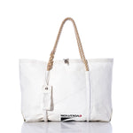 Handcrafted in Maine from recycled sail material, the Sea Bags Vintage Evolution Wharf Tote features a spacious white design with rope handles, a small zipper tag, and the word EVOLUTION partially visible along the lower front—blending classic style with sustainable craftsmanship. by Sea Bags