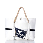 The Sea Bags Vintage UK Sailmakers Wharf Tote is a white handcrafted tote bag, made from recycled sails, featuring a rope handle, a navy logo patch, and a white SEABAGS tag. Displayed against a white background, this tote is inspired by the classic design of the Vintage UK Sailmakers Wharf Tote. by Sea Bags
