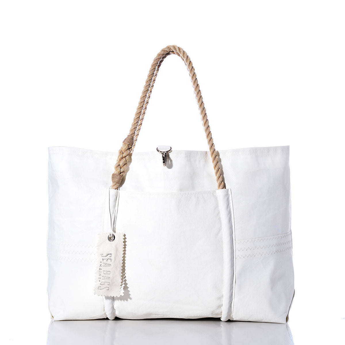 The Sea Bags Vintage Orange Graphic Wharf Tote is a white canvas bag handcrafted in Portland, Maine from recycled sail materials. Featuring rope handles, a front pocket, and a SEA BAGS tag, this tote showcases vintage orange graphic accents inspired by the iconic Wharf Tote design. The product is pictured against a white background. by Sea Bags