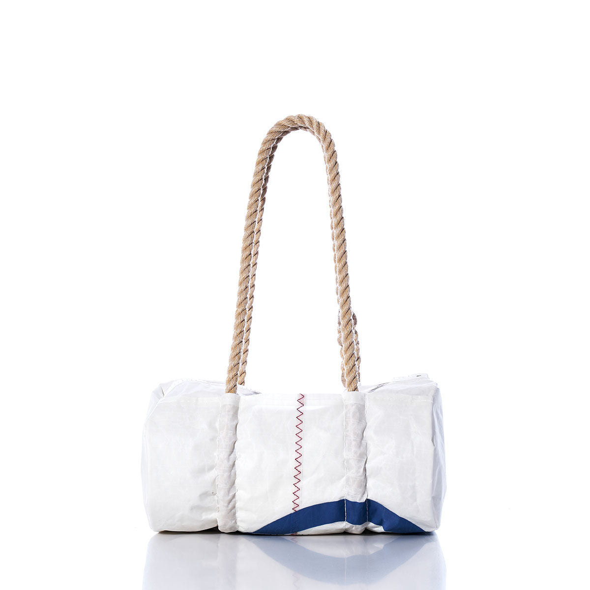 The Sea Bags Vintage Optimist Baguette Bag is a white cylindrical bag with blue accents, red stitching, and two thick rope handles, displayed on a white reflective surface. by Sea Bags