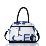 Introducing the Vintage Blue Numbers Essential Weekender Travel Bag by Sea Bags—a white and blue carryon featuring black handles, a detachable strap, front zipper pocket, signature Sea Bags label and hanging tag, plus a convenient trolley sleeve for effortless travel. by Sea Bags