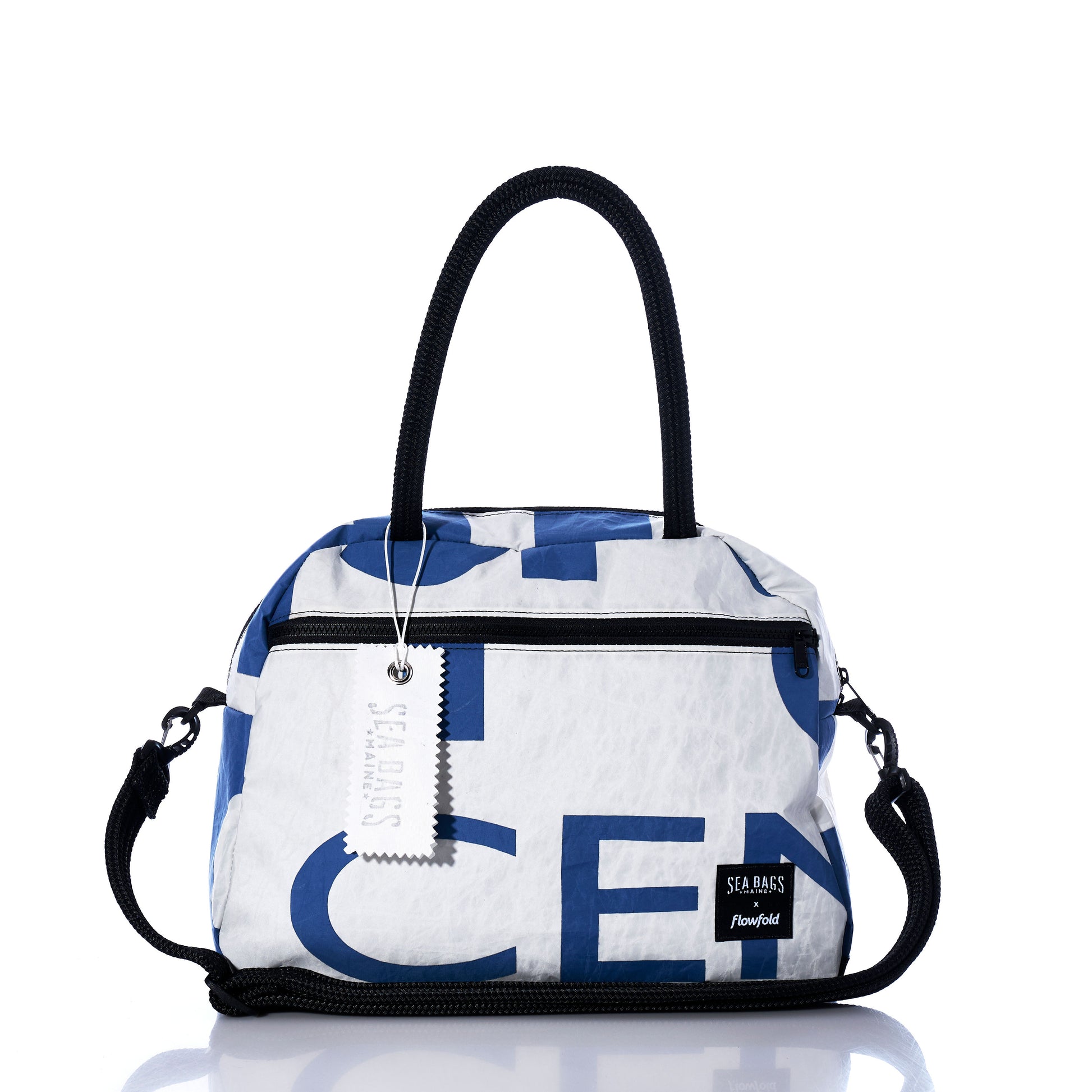 Introducing the Vintage Blue Numbers Essential Weekender Travel Bag by Sea Bags—a white and blue carryon featuring black handles, a detachable strap, front zipper pocket, signature Sea Bags label and hanging tag, plus a convenient trolley sleeve for effortless travel. by Sea Bags